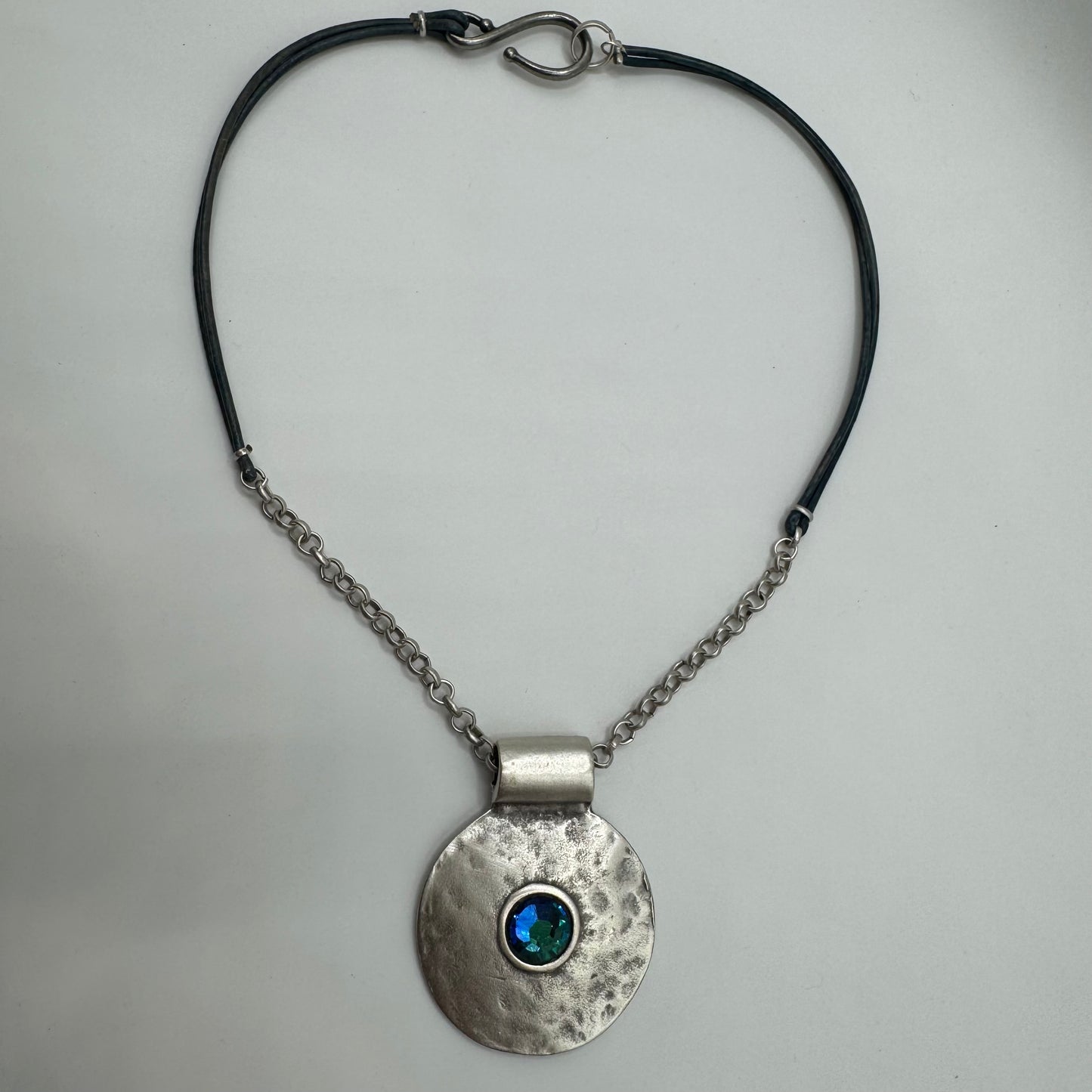Hammered pendant with shimmering blue accent and silver/leather necklace