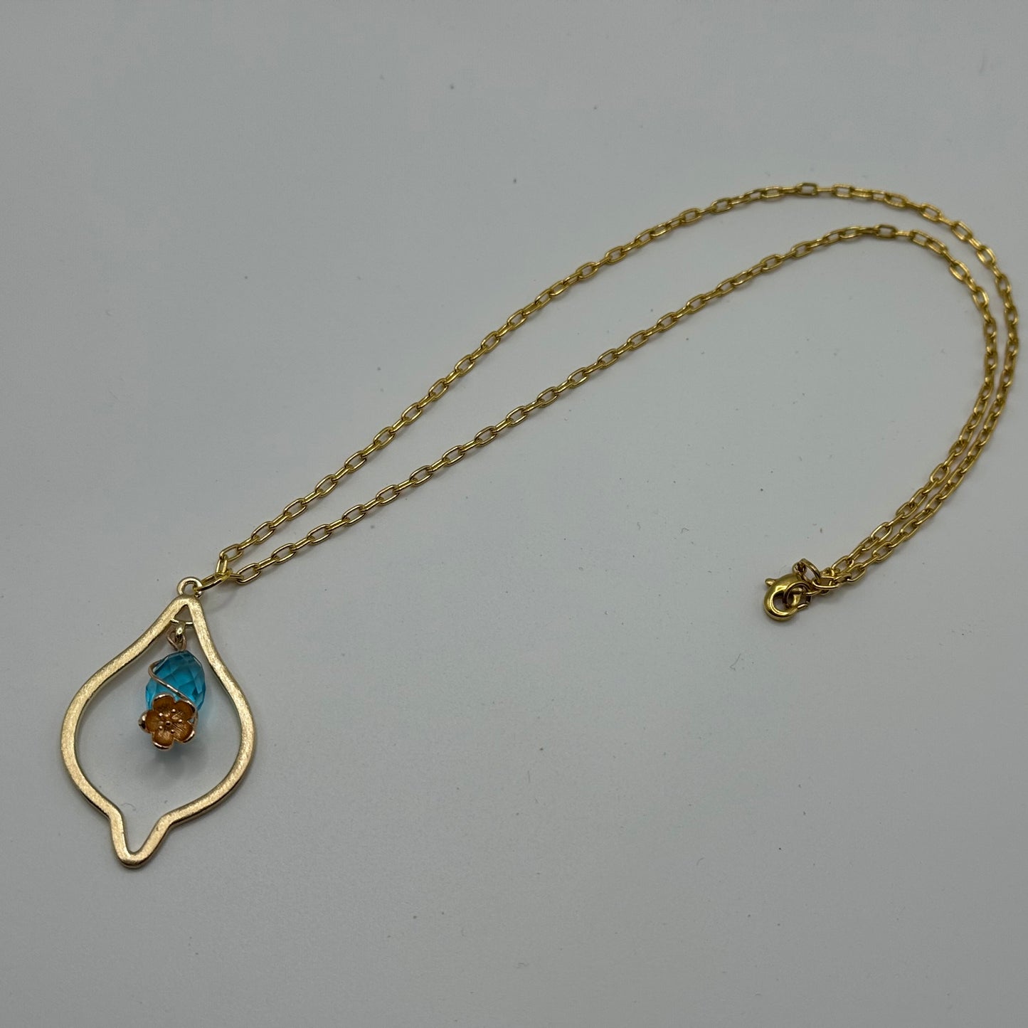 Gold marquise necklace with teal gem and gold flower