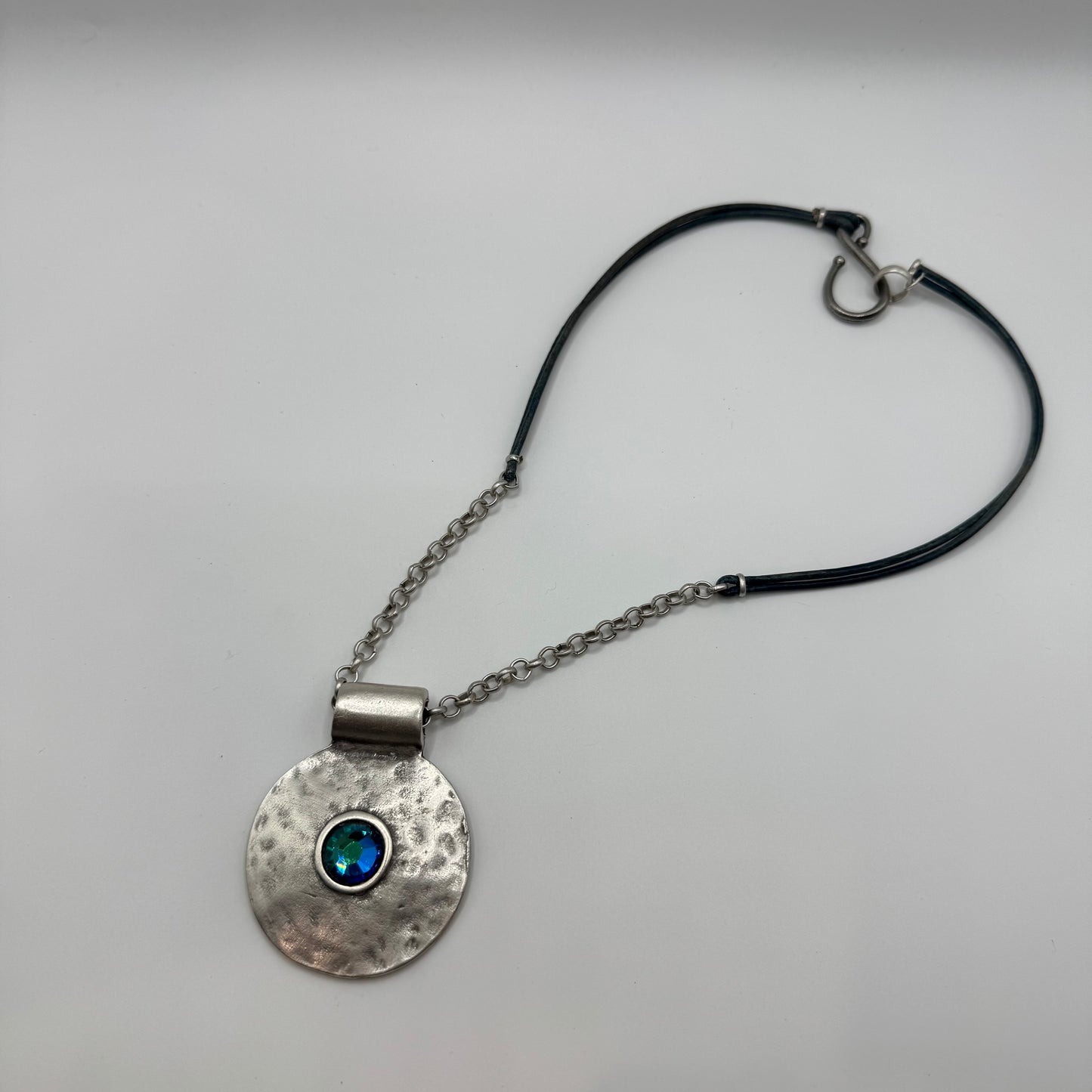 Hammered pendant with shimmering blue accent and silver/leather necklace