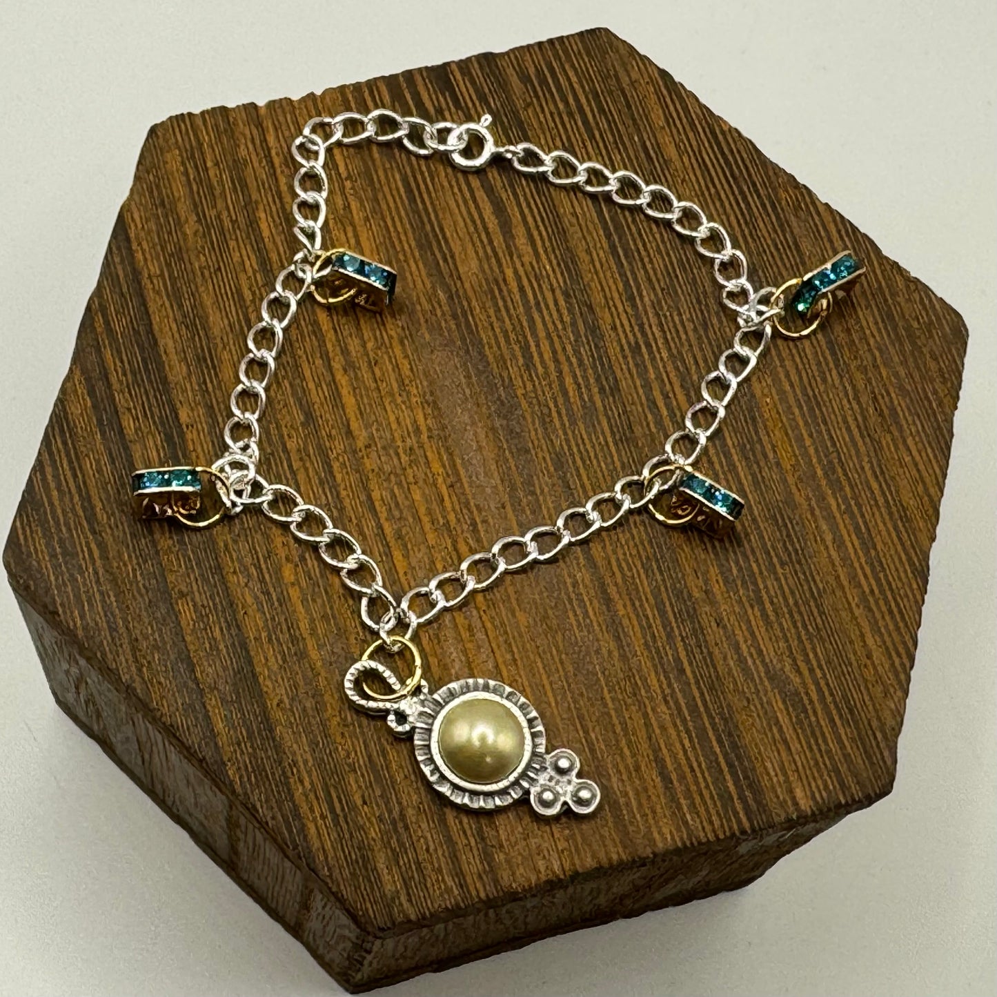 Dazzling mixed-metal bracelet with pearl adorned Victorian charm