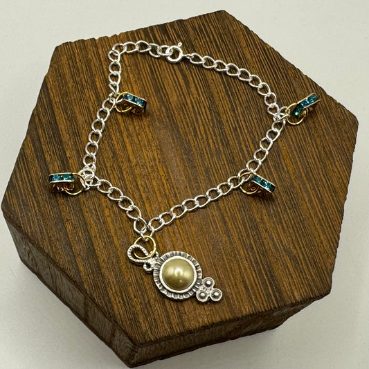 Dazzling mixed-metal bracelet with pearl adorned Victorian charm