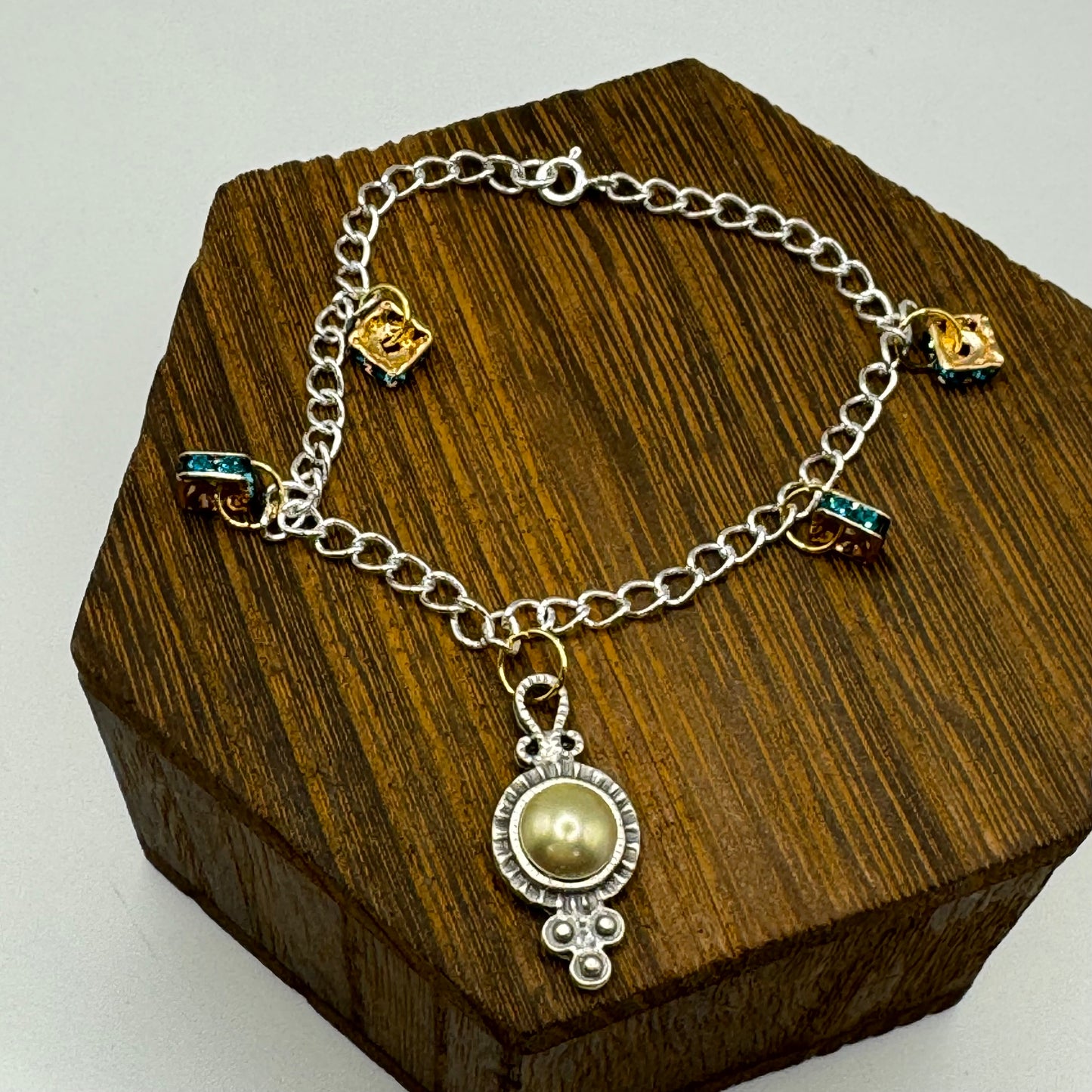 Dazzling mixed-metal bracelet with pearl adorned Victorian charm