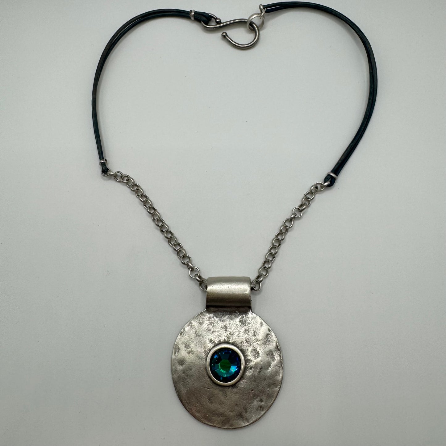 Hammered pendant with shimmering blue accent and silver/leather necklace